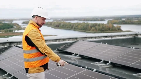 A construction worker inspects solar panels using a walkie-talkie. Vídeo Stock 331518478
