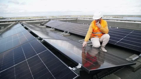 A construction worker inspects solar panels using a walkie-talkie. Vídeo Stock 331518482