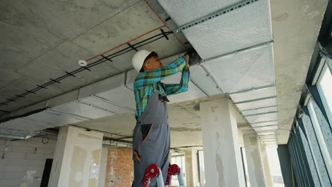 Construction worker installing air duct insulation in building Stock Footage 312837980