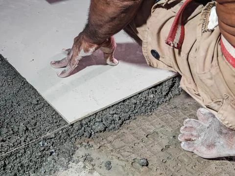 Construction Worker Installing Ceramic Floor Tile With Cement Adhesive Stock Photos