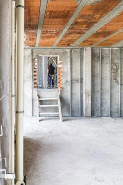 Construction worker installing drywall in a new house building 스톡 사진