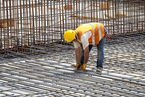 Construction worker installing floor slab reinforcement bars Stock Photos