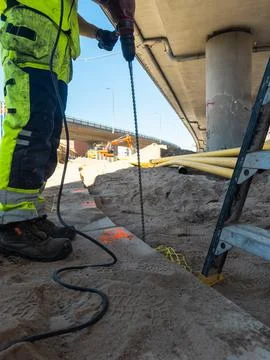 Construction worker installing infrastructure near transportation route Stock Photos