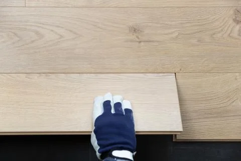 Construction worker installing laminate floor in a new renovated attic. Home Stock Photos