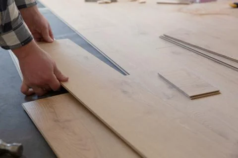 Construction worker installing laminate floor in a new renovated attic. Home Stock Photos
