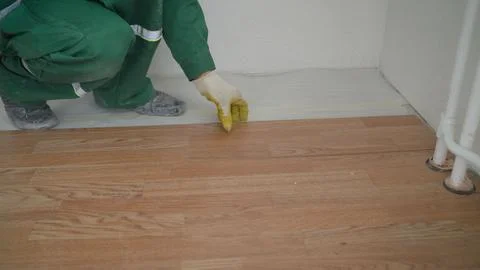 Construction worker installing laminate flooring using hammer Stock Photos