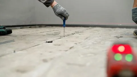 Construction worker installing metal beacons using laser level Stock Photos