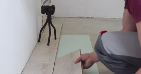 Construction worker installing modern laminate floor in apartment Stock Footage 303708492