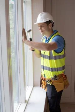 Construction Worker Installing New Windows In House Stock Photos