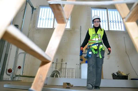 Construction worker installing plasterboard in building renovation project Stock Photos