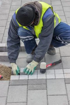 Construction worker installing sidewalk pavement Foto stock