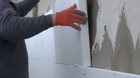 Construction worker installing styrofoam insulation sheets on house Stock Footage 155399128
