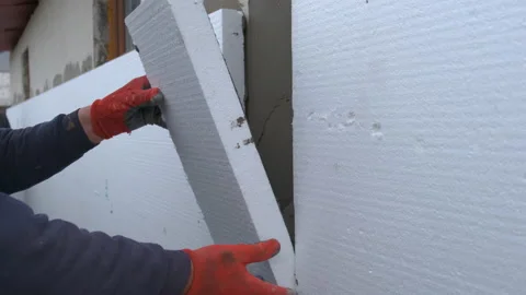 Construction worker installing styrofoam insulation sheets on house facade wall Stock Footage 166220238