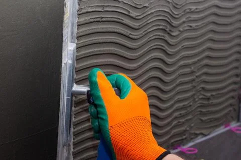 Construction worker installing wall tile at home repair renovation work Stock Photos
