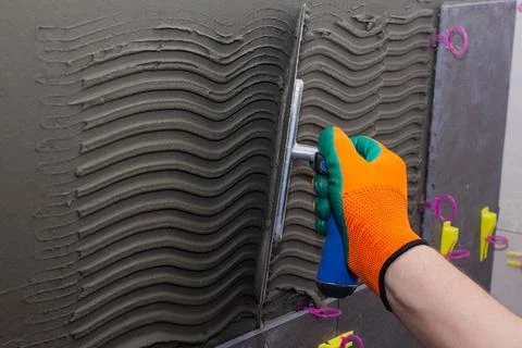 Construction worker installing wall tile at home repair renovation work Stock Photos