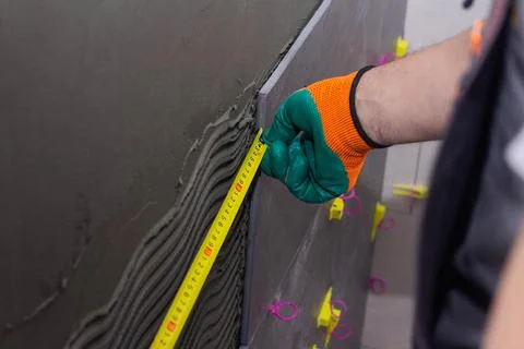Construction worker installing wall tile at home repair renovation work Stock Photos