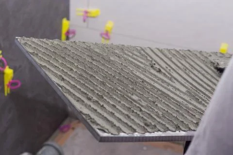 Construction worker installing wall tile at home repair renovation work Stock Photos