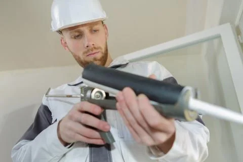 Construction worker installing window in house Stock Photos