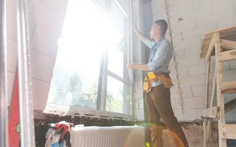 Construction worker installing window in house Foto stock