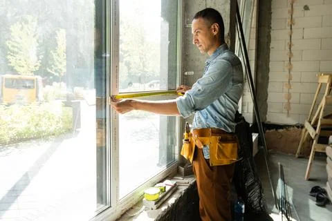 Construction worker installing window in house Stock Photos