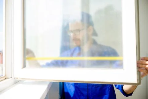 Construction worker installing window Stock Photos
