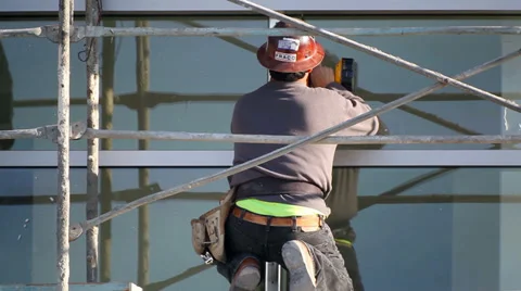 Construction worker installs window at development site 動画素材 33896324