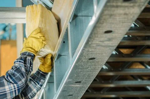 Construction Worker Insulating Frame Elements with a Mineral Wool 写真素材
