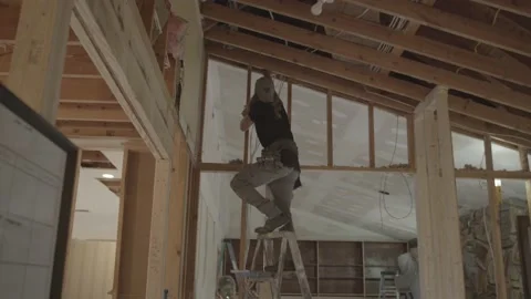 Construction worker is on a ladder adjusting framing Video stock 146197576