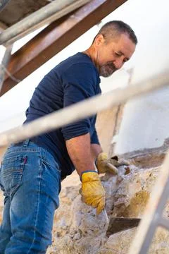 Construction worker on a ladder fixing a wall Stock Photos