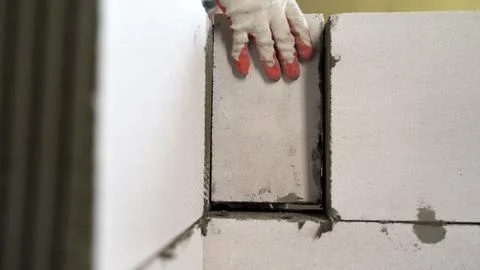 Construction worker laying blocks. Applying an adhesive solution to a foam .. Stock Photos