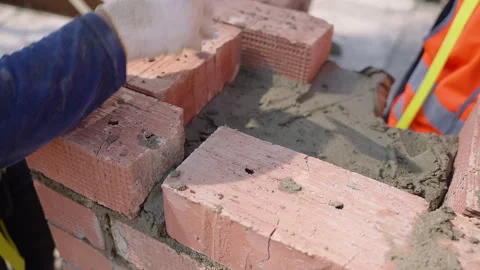 Construction worker laying bricks on brick wall using building material Stock Footage 270229301