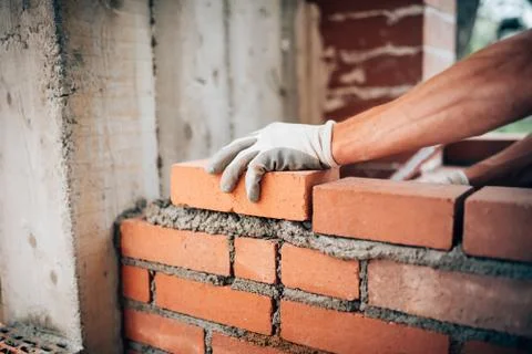 Construction worker laying bricks on exterior walls Stock Photos