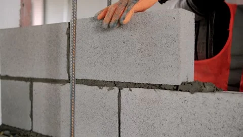 Construction worker laying concrete blocks using mortar of cement and hammer Stock Footage 292617290