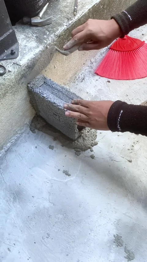 Construction worker laying concrete blocks with cement mortar at building site. Stock Footage 318744746