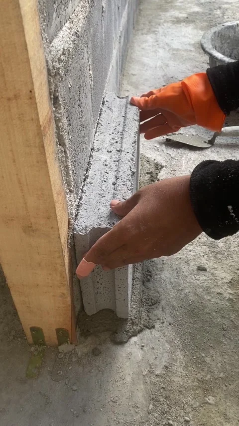 Construction worker laying concrete blocks with cement mortar at building site. Video stock 332565880