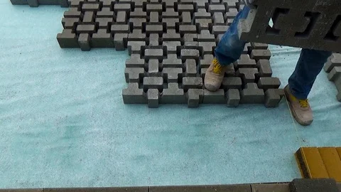 Construction worker laying interlocking paving concrete onto sheet nonwoven b 스톡 동영상 99605008