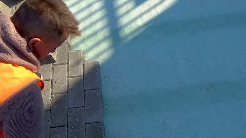 Construction worker laying interlocking paving concrete onto sheet nonwoven b 스톡 동영상 99748724