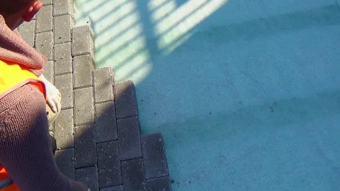 Construction worker laying interlocking paving concrete onto sheet nonwoven b Vídeo Stock 107179080