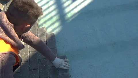 Construction worker laying interlocking paving concrete onto sheet nonwoven b 스톡 동영상 119792101