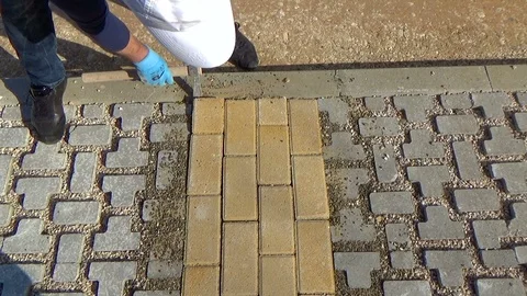 Construction worker laying interlocking paving concrete onto sheet nonwoven b Vídeo Stock 119792392