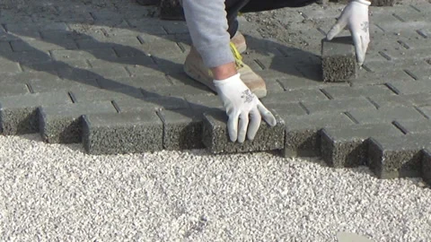 Construction worker laying interlocking paving concrete onto sheet nonwoven b 動画素材 137224848