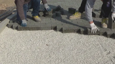 Construction worker laying interlocking paving concrete onto sheet nonwoven b 動画素材 137225132