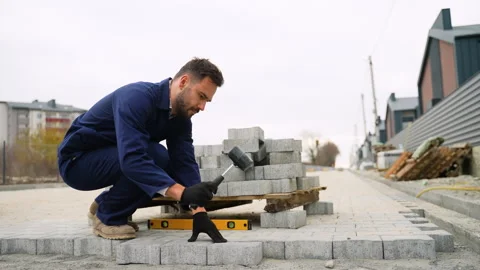 Construction worker laying paving stones in cottage community Video stock 300898334