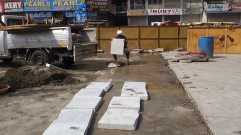 Construction worker laying stone slabs on pavement Stock Footage 83635336