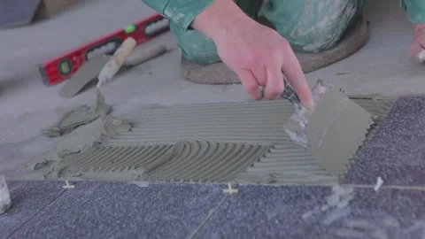 Construction worker laying tiles on the floor for mortar. The builder lays tiles Vidéo 205120366