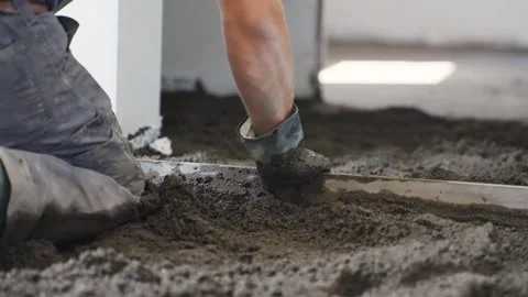 Construction worker leveling concrete floor during building interior works, s Stock Footage 305945986