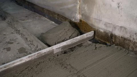 Construction worker leveling fresh concrete screed floor Stock Photos