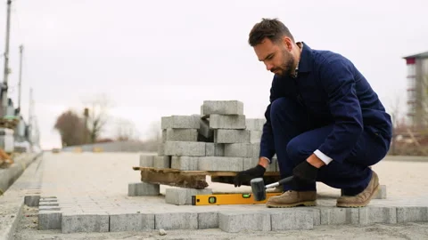 Construction worker leveling paving stones on sidewalk Stock-Footage 300898224