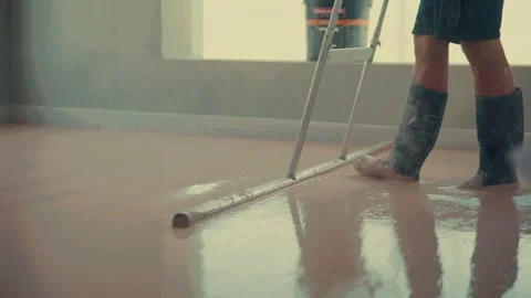 Construction worker leveling self-leveling concrete on floor Stock Footage 316388904