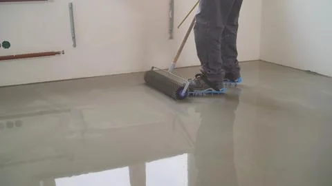 Construction worker leveling wet concrete on a floor Stock Photos